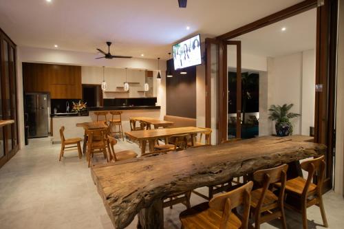 a room with tables and chairs and a kitchen at The Kd Suites & Coffee Shop in Munggu