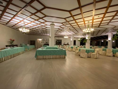 a large banquet hall with green tables and chairs at Hotel Primavera Dell'Etna in Zafferana Etnea
