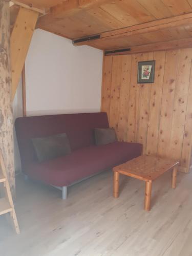 a couch and a table in a room with wooden walls at PICTAVE in Saint-Marcel