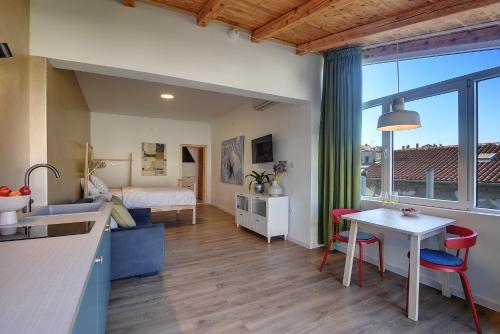 een keuken en een woonkamer met een bed en een tafel bij Apartments Forum 2 in Pula
