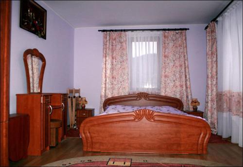 a bedroom with a wooden bed and a window at Panorama in Yaremche