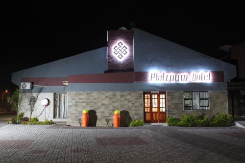 a building with a sign on the side of it at night at Platinum Hotel in Gaborone