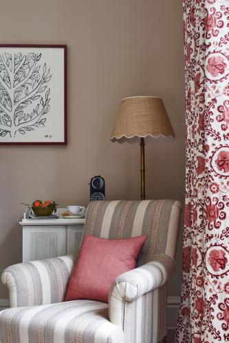 a living room with a chair and a red pillow at Wildhive Callow Hall in Ashbourne