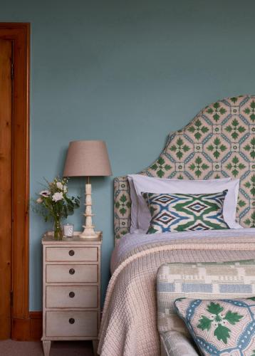 a bedroom with a bed and a nightstand with a lamp at Wildhive Callow Hall in Ashbourne