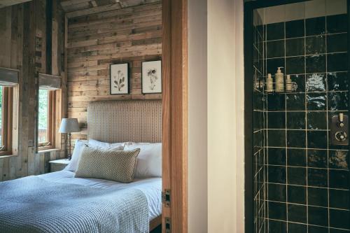 a bedroom with a bed and a glass wall at Wildhive Callow Hall in Ashbourne
