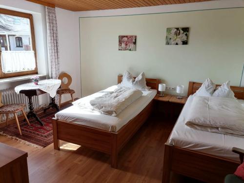 1 Schlafzimmer mit 2 Betten, einem Tisch und einem Fenster in der Unterkunft Gasthof zur Post in Schonstett