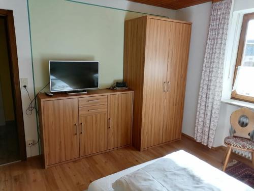 a bedroom with a tv on top of a wooden cabinet at Gasthof zur Post in Schonstett