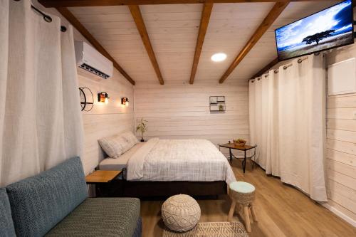 een slaapkamer met een bed en een tv. bij אצלנו בחצר in Avnei Eitan