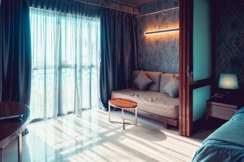 a bedroom with a couch and a table and a window at Seaview Suites at Admiral Bay in Port Dickson