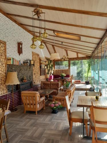 un restaurant avec des plafonds en bois, des tables et des chaises dans l'établissement Cabana Ancutei, à Rucăr