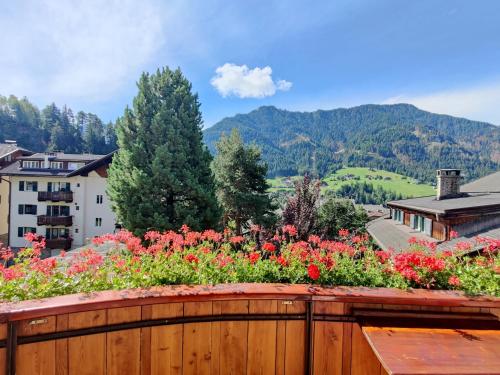 a garden with flowers on a wooden fence at AppartChalet LA RONDULA - 100m from Seceda in Ortisei