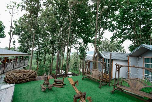 a yard with a playground with chairs and trees at One khaokho homestay in Khao Kho