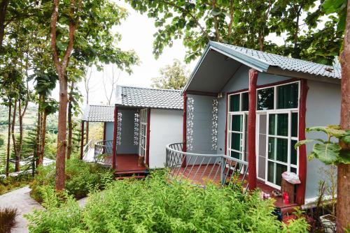 a small house with a red deck and trees at One khaokho homestay in Khao Kho