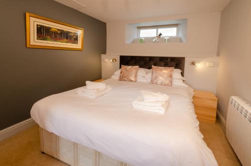 a bedroom with a large white bed with towels on it at Langdale Retreat in Chapel Stile
