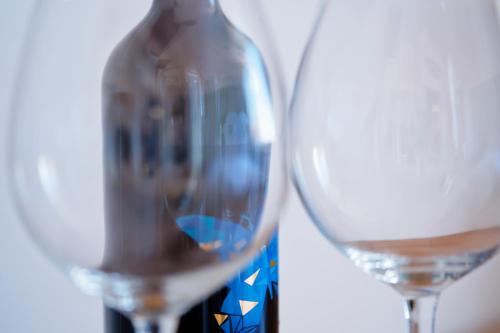 a bottle of wine and two wine glasses at Luma Terra Prague Hostel in Prague