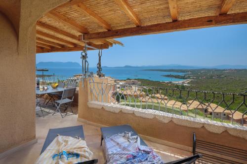 a balcony with a table and chairs and a view of the ocean at Appartamento Smeralda - SHERDENIA Luxury Apartments in Marinella