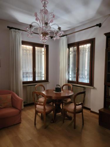 uma sala de jantar com uma mesa e cadeiras e um lustre em Casa Perugina em Montagnana