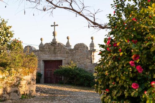 an old church with a cross on top of it at Vinte-Quinta da Boavista in Ponte de Lima