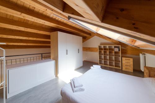 a attic bedroom with a large bed and wooden ceilings at Hbhall Residenze Darsena in Milan