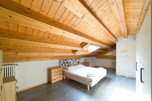 a large room with a bed and wooden ceilings at Hbhall Residenze Darsena in Milan
