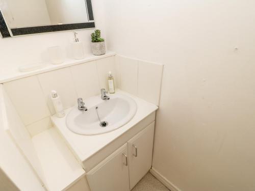 a white bathroom with a sink and a mirror at 3 Mill Wynd in Darlington