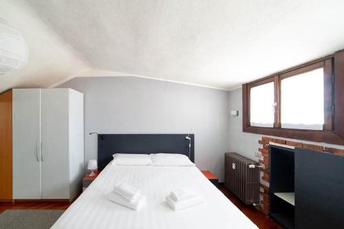 a bedroom with a large white bed and a fireplace at Hbhall Residenze Darsena in Milan