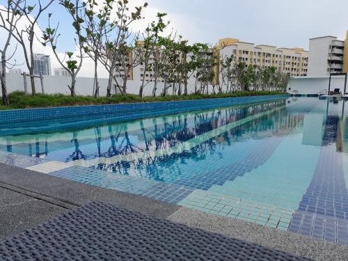 a swimming pool in a building with trees and buildings at The Landmark Comfort Relax Spacious Sea View By IZ in Tanjong Tokong