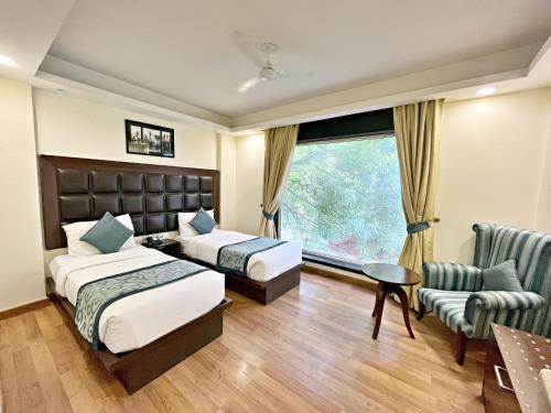Habitación de hotel con 2 camas y ventana en The Grand Orion - Kailash Colony, en Nueva Delhi