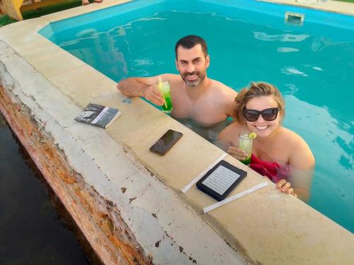 a man and woman in a swimming pool with drinks at Fenti Nubian Resort in Aswan