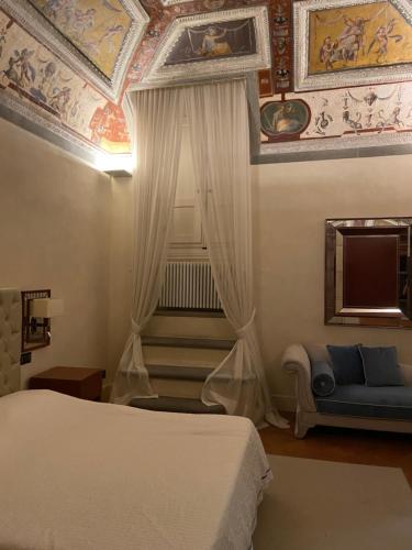 a bedroom with a bed and a couch and a ceiling at Luxury frescoed apartment in the center in Florence