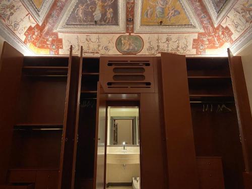 a bathroom with a sink and a ceiling with paintings at Luxury frescoed apartment in the center in Florence