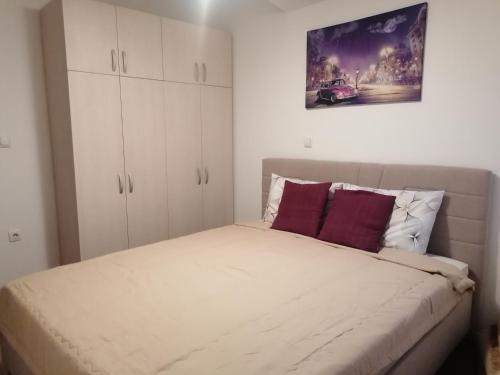 a bedroom with a bed with white cabinets at Ano's Apartment in Štip