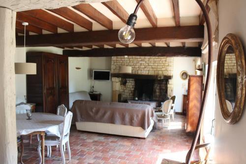 Una sala de estar con un sofá y una chimenea. en La Cour Martin à 7 km d'Etretat-Gîte classé 3 étoiles, en Cuverville