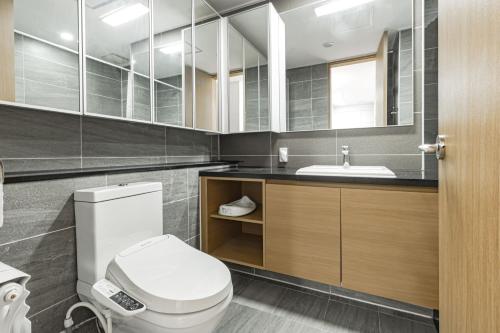 a bathroom with a white toilet and a sink at Highvill park apart in Astana