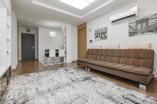 a living room with a couch and a rug at Highvill park apart in Astana