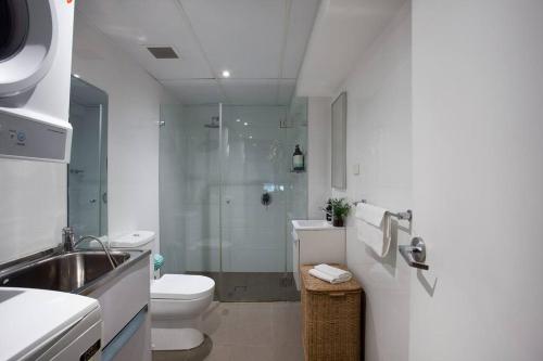 ein Bad mit einer Dusche, einem WC und einem Waschbecken in der Unterkunft New York Style Warehouse Loft by Sydney Dreams in Sydney