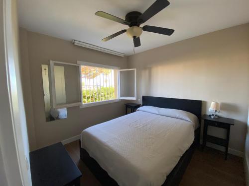 1 dormitorio con 1 cama y ventilador de techo en Precioso apartamento junto a playa y con piscina., en Málaga