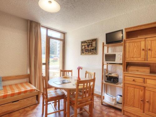 une cuisine avec une table et des chaises ainsi qu'une chambre dans l'établissement Charmant studio tout équipé pour 2 pers, Serre-Chevalier, parking et casier à ski inclus - FR-1-330E-66, à Saint-Chaffrey