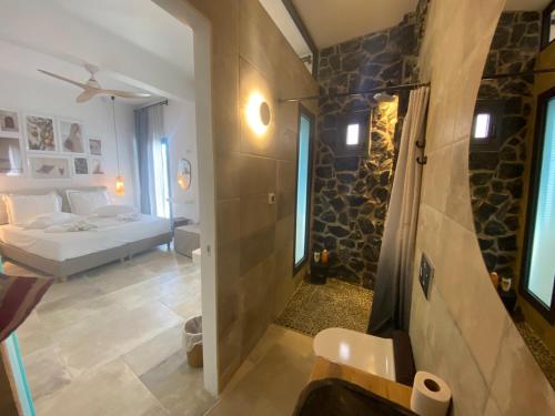 ein Schlafzimmer mit einem Bett und ein Badezimmer mit einer Dusche in der Unterkunft Kores of Poros in Poros