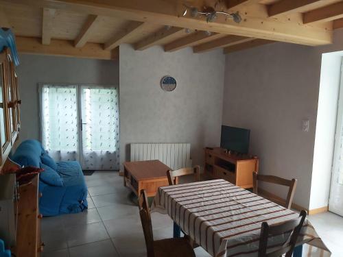 un salon avec une table et une télévision dans l'établissement jonzac-gite-lepuits, à Clion