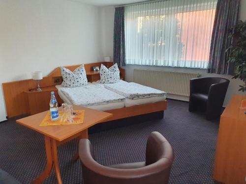 une chambre d'hôtel avec un lit, une table et des chaises dans l'établissement Hotel Pension Störtebeker, à Biendorf