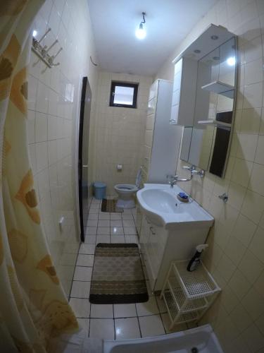 a white bathroom with a sink and a toilet at VuBra in Ulcinj