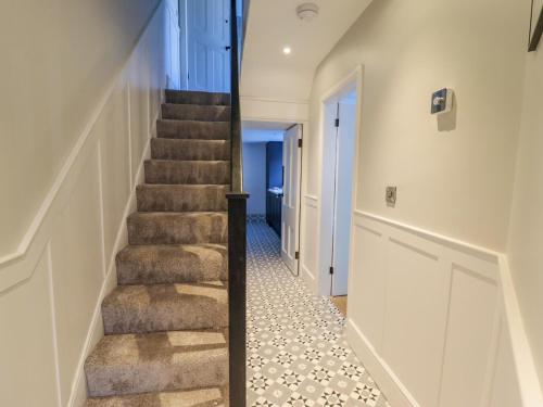 a staircase in a house with a hallway at Rhif Saith in Ruthin