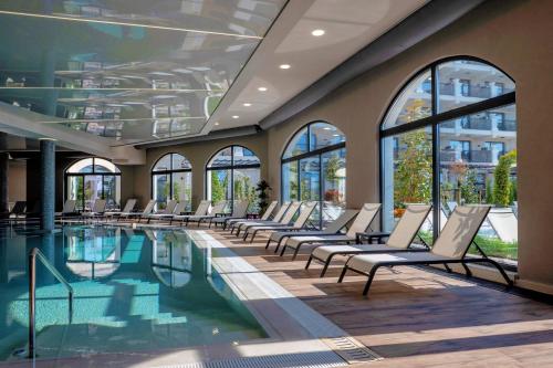 una piscina con tumbonas en un edificio en Casa di Fiore SPA and Medical Hotel, Mineral Pools & Private Beach, en Kranevo