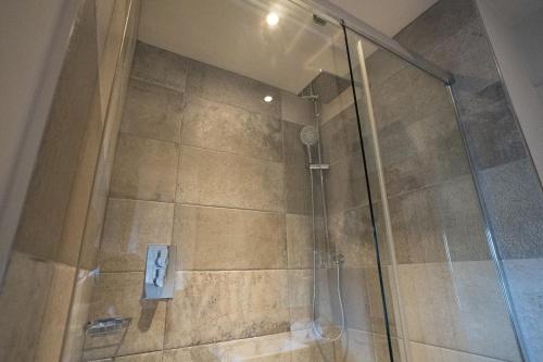 a shower stall with a glass door in a bathroom at The Inn South Stainley in Harrogate