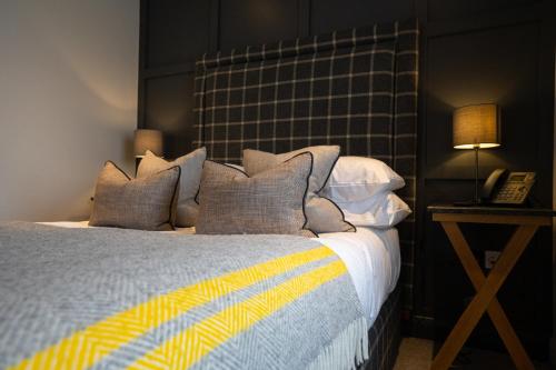 a bedroom with a bed with pillows and a telephone at The Inn South Stainley in Harrogate