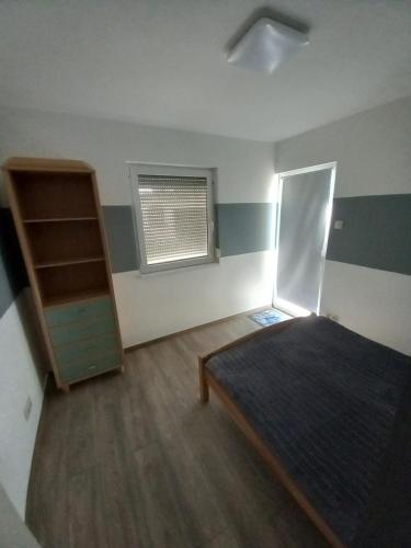 ein leeres Zimmer mit einem Bett und einem Fenster in der Unterkunft Csalogány Villa Balatonboglár in Balatonboglár