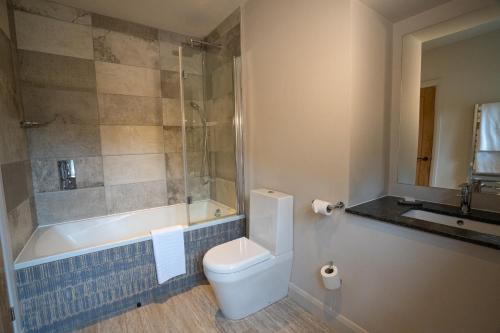 a bathroom with a toilet and a tub and a sink at The Inn South Stainley in Harrogate