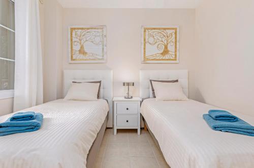 2 camas individuais num quarto com paredes brancas em SMART-Beachview em Costa Calma