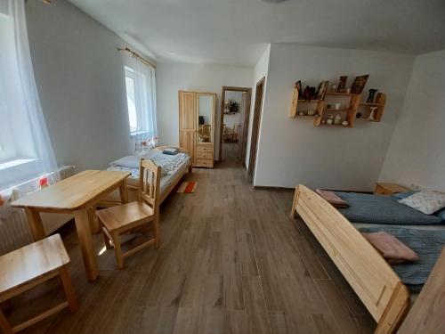 a room with two beds and a table and a dining room at Fazekas Vendégház in Balatonkeresztúr